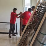 Furniture movers Dubai transporting sectional sofa down staircase