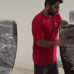 Furniture movers Dubai transporting sectional sofa down staircase